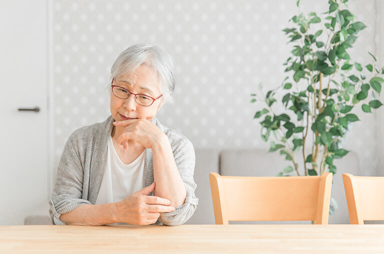 憂鬱な表情の高齢者女性